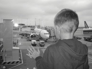 bimbo che guarda gli aerei oltre il vetro