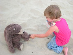 Matilde con il suo orsetto compagno di vacanza sulla spiaggia